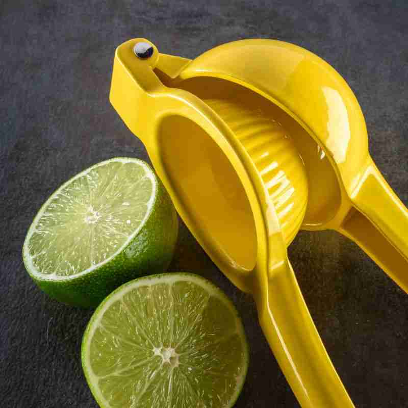 yellow metal citrus juicer with fresh limes