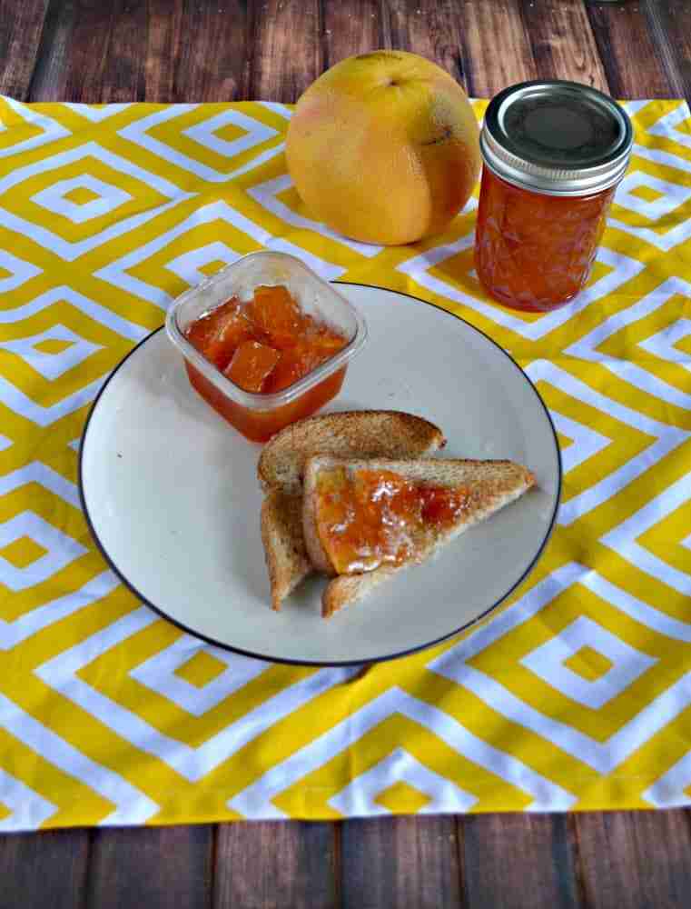 Grapefruit marmalade with vanilla with fresh grapefruit and toast on white and yellow cloth