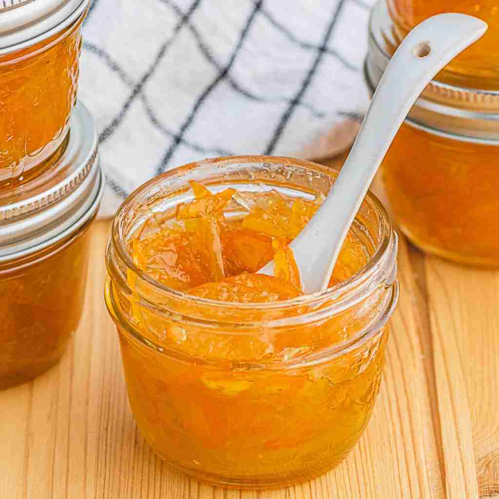 Kumquat marmalade with bergamot in glass gar with white spoon