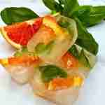 blood orange and basil ice cubes with fresh basil leaves and orange
