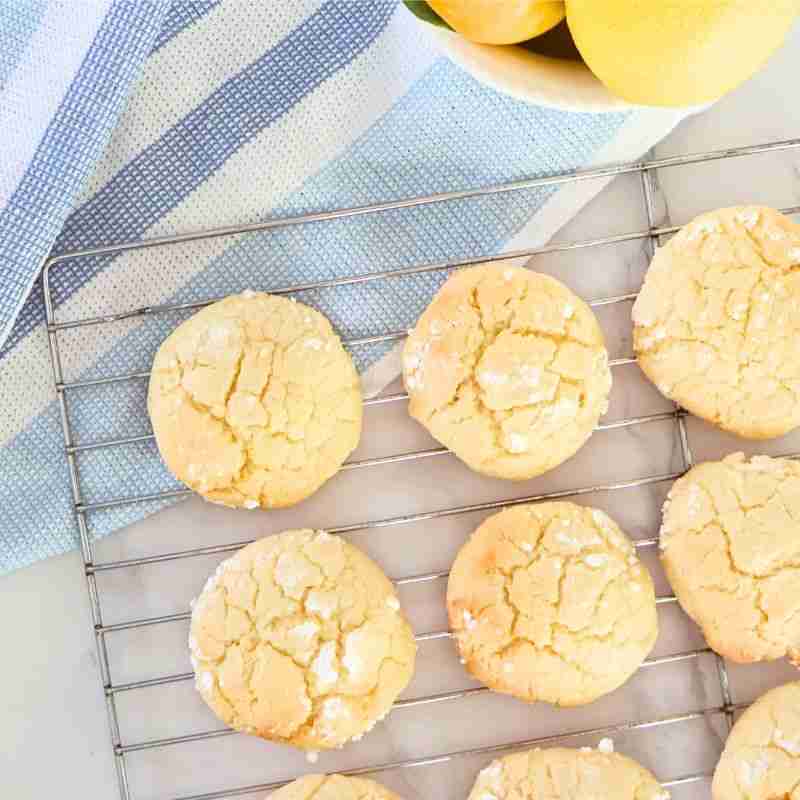 lemon macadamia cookies on wire rack with blue and white striped cloth