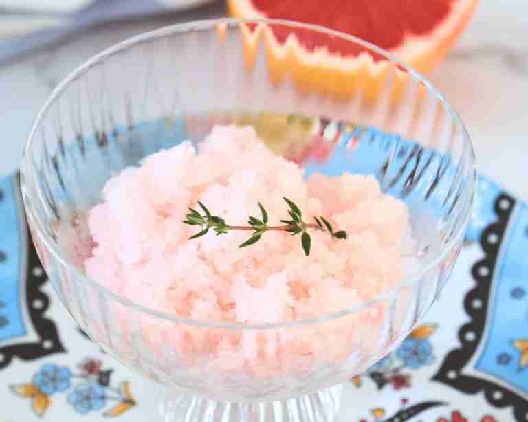 grapefruit granita with vanilla and thyme in a glass dish on a blue floral plate