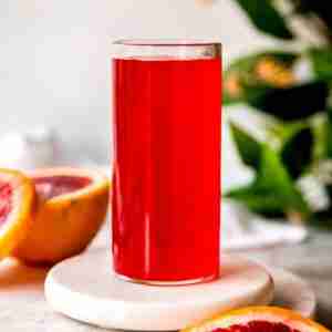 bright red blood orange syrup with fresh blood oranges