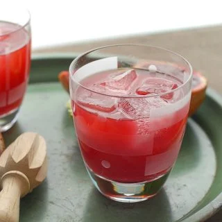 blood orange ginger margarita in glass with reamer