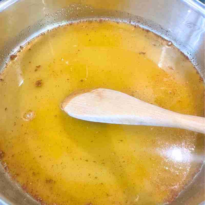 step by step images showing stiring orange candied almonds in a saucepan until sugar mixture crystalises