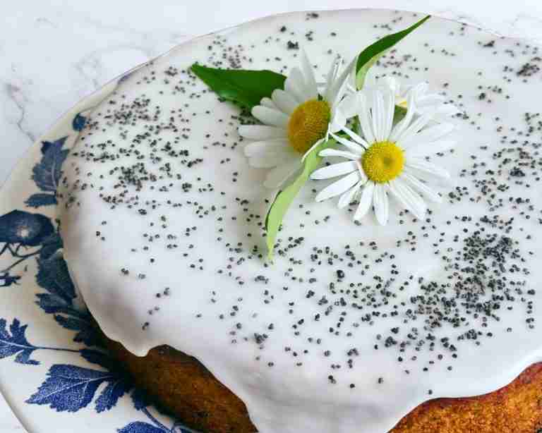 whole lemon and poppy seed cake with lemon glaze and daisies