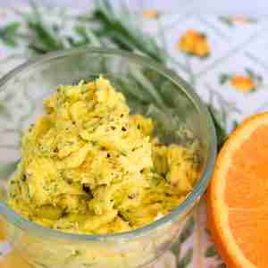 compund orange butter with pepper and rosemary in glass dish