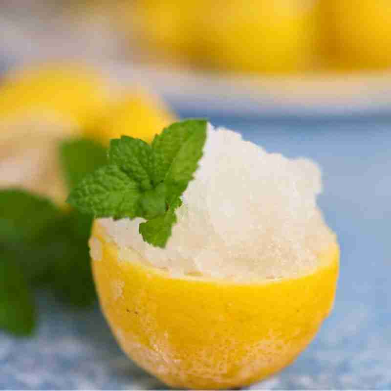 lemon granita in a fresh lemon half with mint garnish