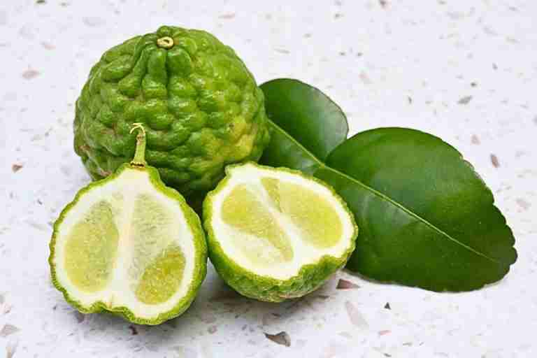 whole and half kaffir lime fruit with leaf